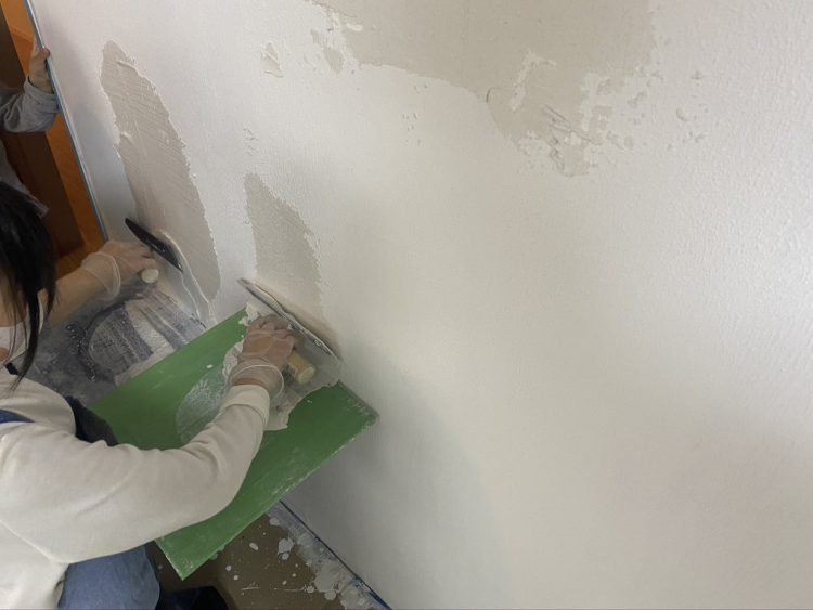 大垣市にあるリノベーション住宅で子供がDIYで壁に漆喰を塗る様子