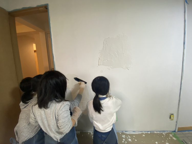 大垣市にあるリノベーション住宅で子供がDIYで壁に漆喰を塗る様子2